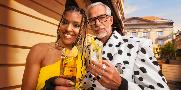 Zwei Personen genießen Schweppes Getränke in der Stadt, strahlend und modisch.