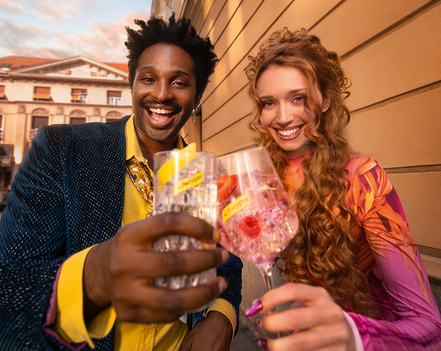 Stilvolle Menschen genießen ihre Schweppes Mix-Getränke im Freien.