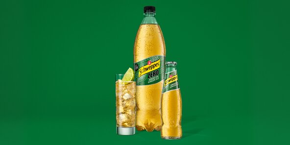 Hero-Motiv: Schweppes American Ginger Ale Glasflasche neben Zero PET-Flasche auf grünem Hintergrund.