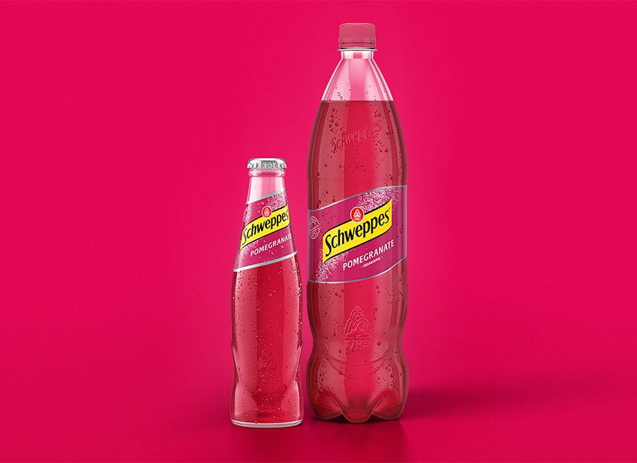 Schweppes Pomegranate – Glasflasche neben 1,25-l Flasche, beide mit Kondensperlen.